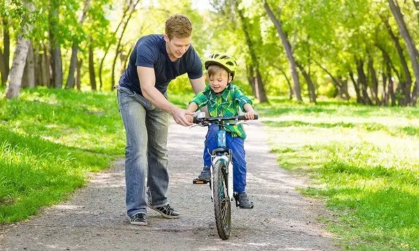 guidare un bambino su una bicicletta a due ruote