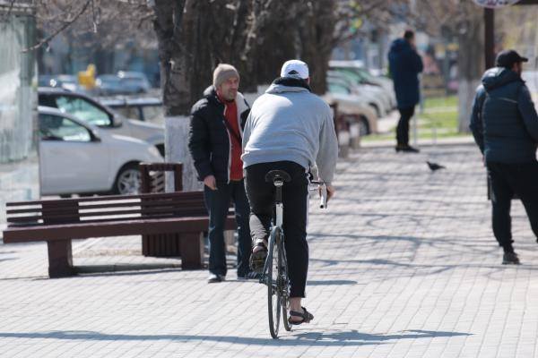 ciclista che pedala sul marciapiede